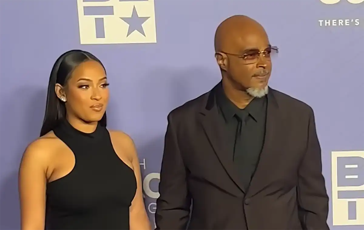 Jolie Ivory Wayans standing with her father Keenen Ivory Wayans at a red carpet event.