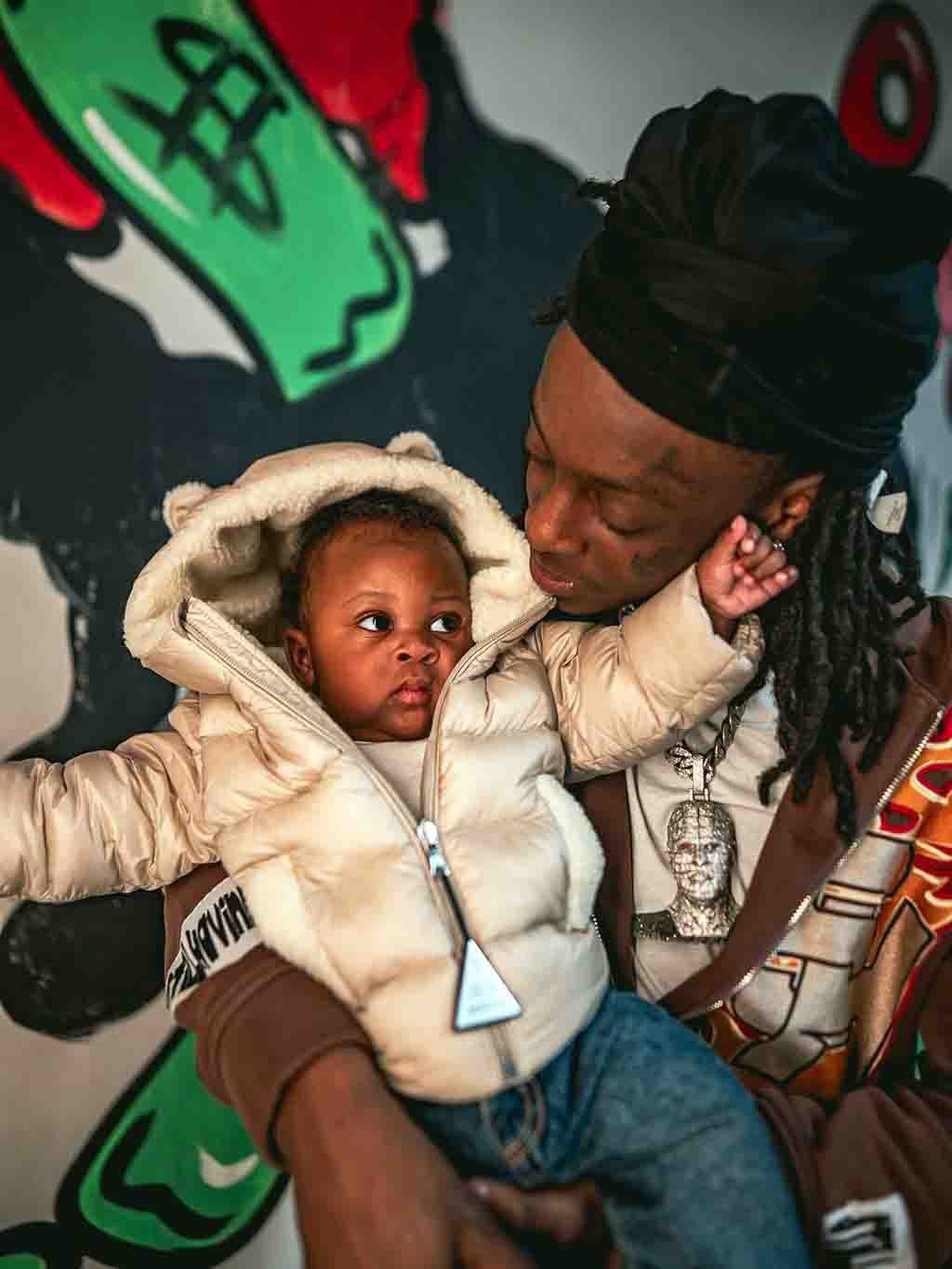Raq Baby holding his child in late 2025